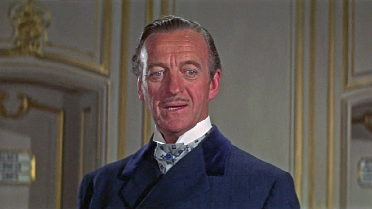 David Niven David Niven từng hóa thân James Bond trong Casino Royale (1967) - phiên bản mang màu sắc châm biếm, nơi nhân vật nghỉ hưu nhưng bị kéo trở lại để chống tổ chức Smersh. Theo Guardian, màn thể hiện của ông nhận nhiều lời khen khi bộc lộ nét lịch lãm, dí dỏm hơn hình tượng điệp viên lạnh lùng của hãng phim Eon. Ông tên thật James David Graham Niven (1910-1983), là diễn viên, nhà văn người Anh, nổi tiếng với hình tượng quý ông lịch lãm của Hollywood cổ điển. Ông giành một giải Oscar, hai Quả Cầu Vàng cùng nhiều đề cử BAFTA và Emmy. Năm 1940, Niven kết hôn với Primula Susan Rollo sau thời gian ngắn hẹn hò, có hai con trai. Tuy nhiên, Primmie qua đời năm 1946 ở tuổi 28 sau tai nạn ngã cầu thang tại nhà diễn viên Tyrone Power ở Beverly Hills (Mỹ). Năm 1948, Niven cưới người mẫu Thụy Điển Hjördis Paulina Tersmeden. Từ năm 1978, sức khỏe Niven suy giảm với các triệu chứng sụt cân, mệt mỏi, yếu cơ và nói khó. Ông được chẩn đoán mắc bệnh ALS (xơ cứng teo cơ một bên) năm 1980 và qua đời tại nhà riêng ở Thụy Sĩ ba năm sau đó, hưởng thọ 73 tuổi. Ảnh: Columbia Pictures