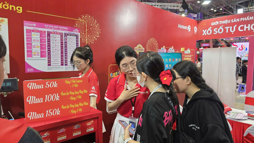Nhân viên tư vấn cho khách tham quan cách mua để hưởng ưu đãi và check-in nhận quà. Ảnh: Vietlott