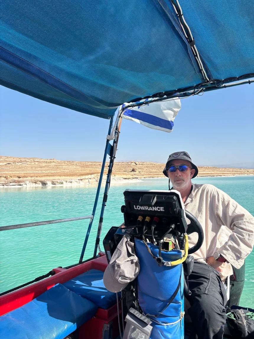 Jake Ben Zaken, nhà sáng lập công ty tour Salty Landscapes, lái thuyền trên Biển Chết, tháng 5. Ảnh: CNN Giới chuyên gia thống nhất rằng không giải pháp nào có thể khôi phục Biển Chết trở lại như vài thập kỷ trước, trọng tâm mới nên hướng tới mục tiêu giữ bình ổn mức độ suy giảm của vùng nước này. Trong khi cơ quan chức năng chưa có giải pháp, người dân sinh sống và kinh doanh dọc bờ biển tiếp tục cuộc sống thường nhật trong nỗi bất an. Ben Zaken của Salty Landscapes biết rằng thời gian của họ đang cạn dần. Mỗi lần đến bãi biển khởi hành tour du thuyền, ông đều quan sát cát xem có hố sụt nào hay không. Nếu hố sụt lại xuất hiện, ông sẽ phải dừng hoạt động công ty ngay lập tức, trong khi họ không thể mua bảo hiểm cho một hoạt động kinh doanh chắc chắn rủi ro. “Mọi thứ ở đây không thay đổi từ từ, mà là một thảm họa diễn ra với tốc độ nhanh chóng”, ông Ben nói.
