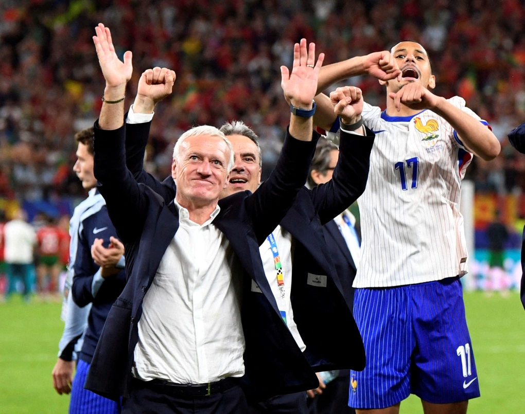 HLV Didier Deschamps và trung vệ Wiliam Saliba (số 17) mừng sau khi Pháp hạ Bồ Đào Nha bằng loạt luân lưu ở tứ kết Euro 2024 trên sân Volkspark, Hamburg, Đức ngày 5/7. Ảnh: Reuters