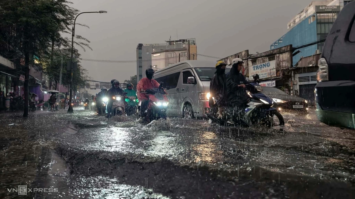 Cách đó khoảng 3 km, mưa lớn cũng gây ngập nửa bánh xe máy trên tuyến đường Đinh Bộ Lĩnh, đoạn gần bến xe miền Đông cũ. Bốn ngày trước, cơn mưa lớn vào giờ tan tầm buổi chiều cũng khiến khu vực này chìm trong nước, ảnh hưởng nhiều hộ dân.