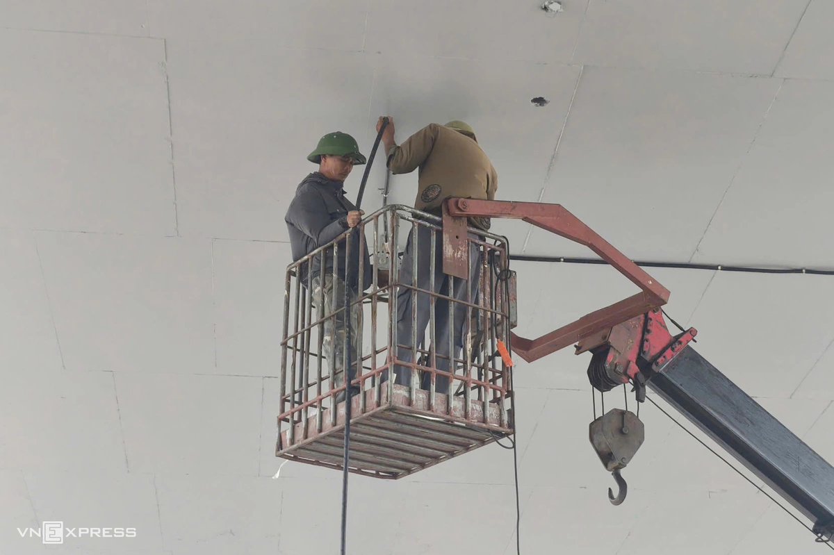 Công nhân đang hoàn thiện hệ thống điện chiếu sáng phía dưới gầm cầu vượt.