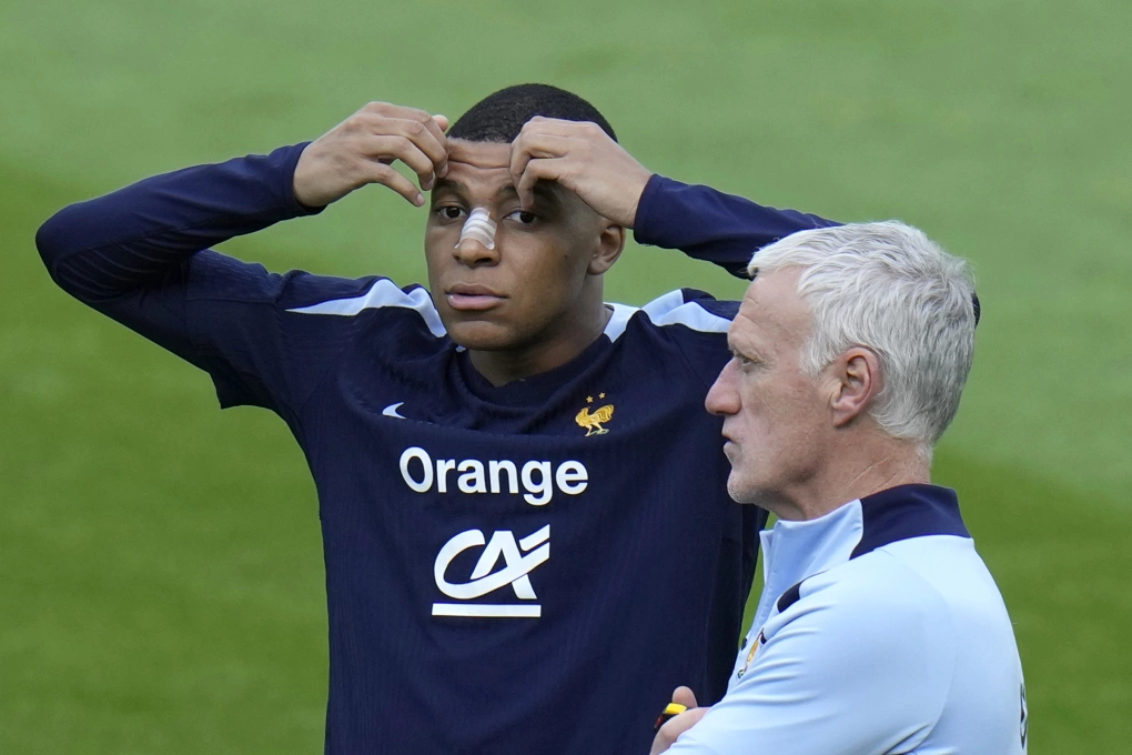 Tiền đạo Kylian Mbappe trao đổi với HLV Didier Deschamps trên sân tập cùng tuyển Pháp tại Paderborn, Đức ngày 19/6/2024. Ảnh: AP