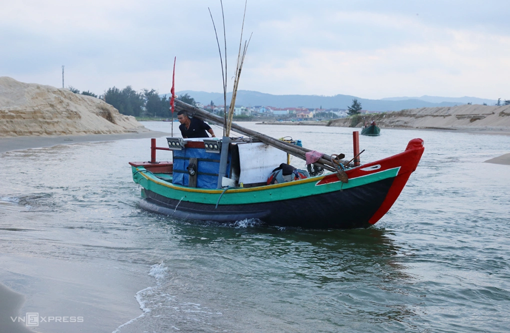 Ông Hồ Sĩ Quang chèo lái thuyền qua lạch sâu khoảng nửa mét ra khơi đánh bắt. Ảnh: Đắc Thành
