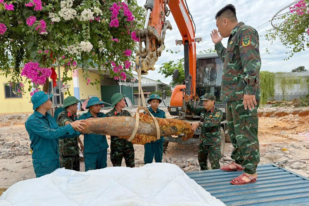Lực lượng chức năng di chuyển quả bom đưa đi hủy nổ, sáng 24/6. Ảnh: Trọng Kiên