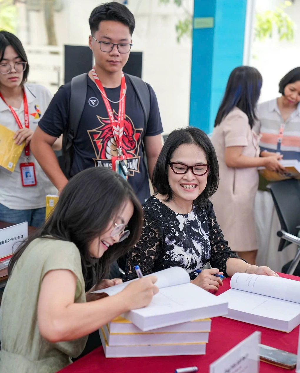 PGS.TS Nguyễn Phi Lê và GS.TS Thái Trà My (từ trái qua) ký tặng sách, sáng 25/6. Ảnh: AI4Life