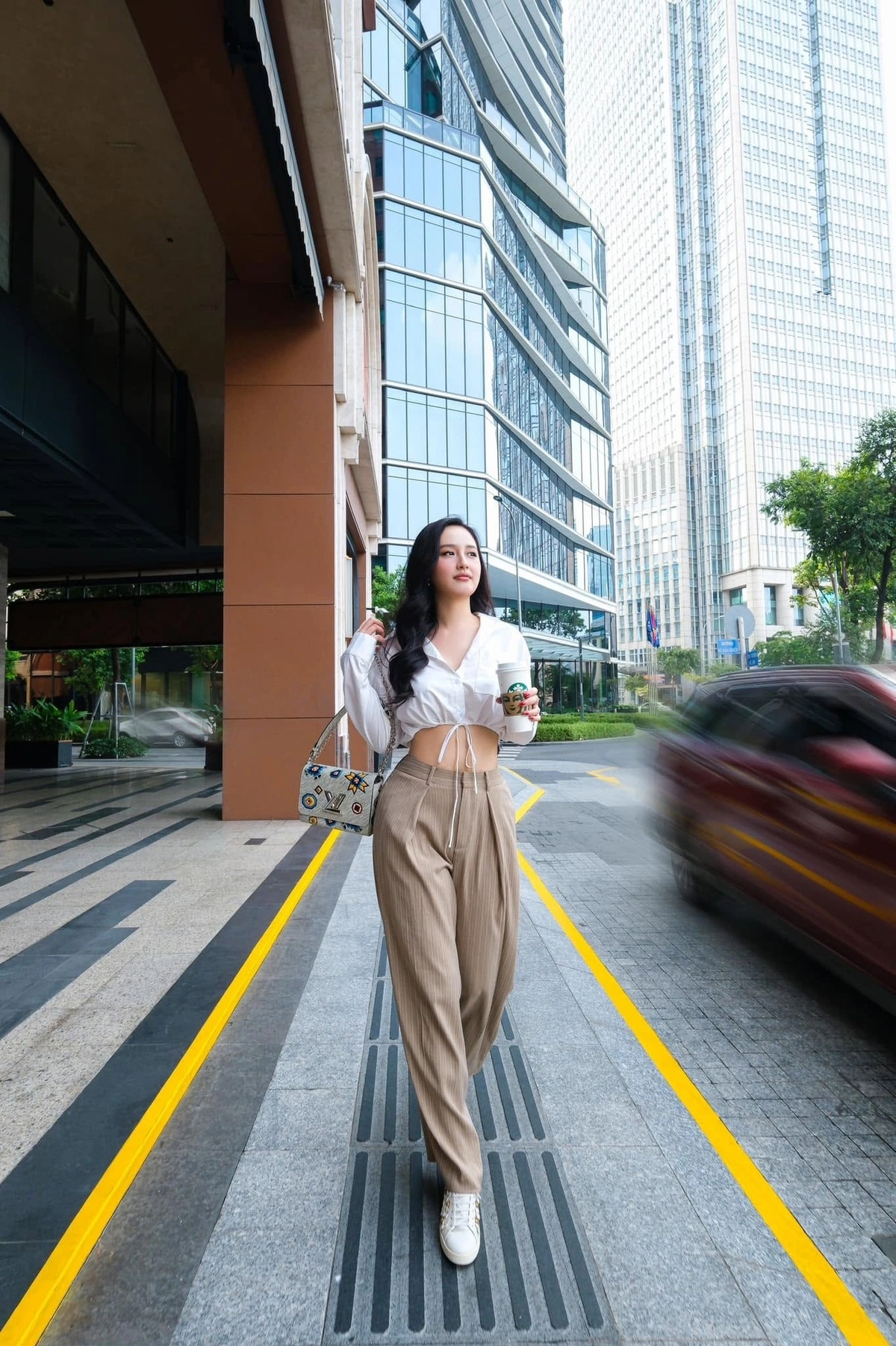 Thời trang mùa hè hướng tới sự thoải mái của Mai Phương Thúy với sơ mi dây rút dáng crop top, quần vải baggy. Cô xách túi Twist MM phiên bản giới hạn của Louis Vuitton.