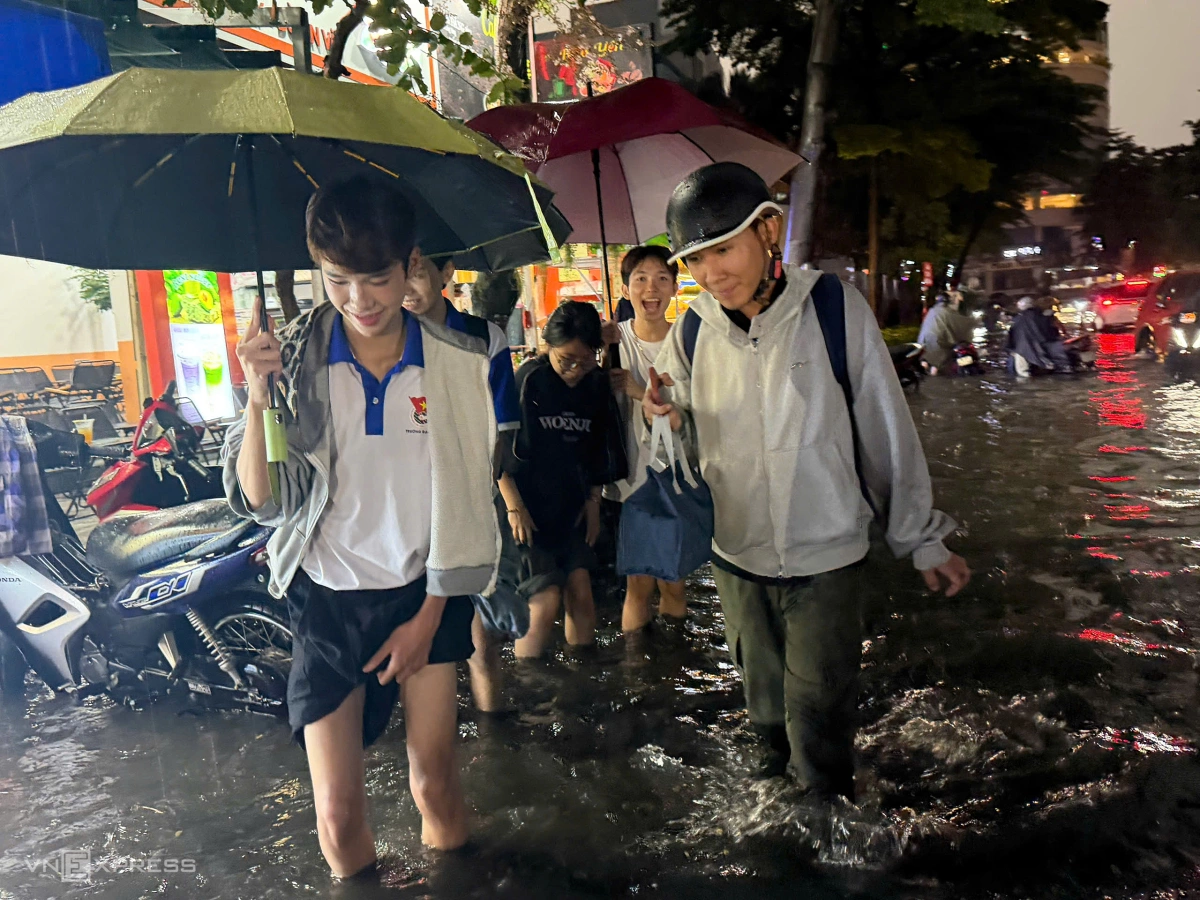 Nhóm sinh viên Đại học Văn Hóa lội nước về nhà. "Vừa học về là chúng em thấy đường ngập sâu", sinh viên Nguyễn Trọng Phúc (góc trái) nói.
