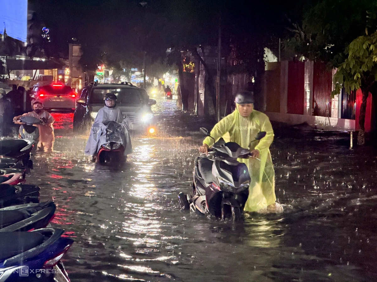 Gần đó, đường Xuân Thủy cũng lênh láng nước. Nhiều xe không thể nổ máy, người dân phải đẩy qua đoạn ngập.