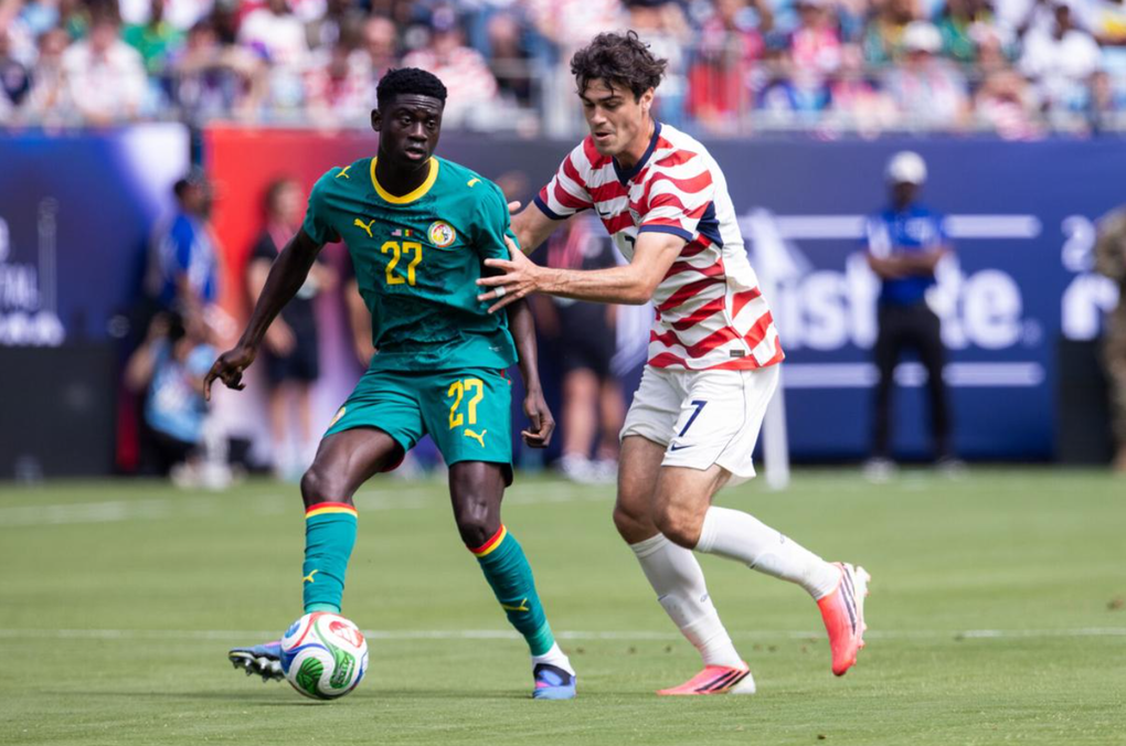 Bara Sapoko Ndiaye (áo xanh) chuyền bóng khi chịu tác động từ Giovanni Reyna trong trận giao hữu giữa Senegal và Mỹ tại Charlotte, Mỹ ngày 31/5/2026. Ảnh: AP