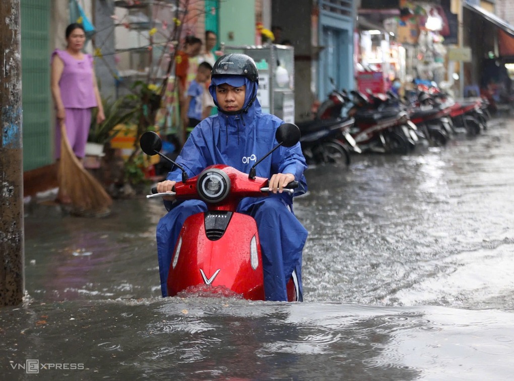 Mưa ngập hơn nửa bánh xe trên đường Trương Văn Ngư, TP Thủ Đức cũ, chiều 2/5. Ảnh: Quỳnh Trần
