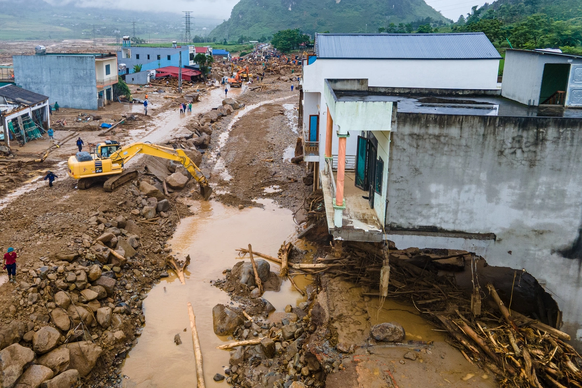 Máy xúc liên tục di chuyển những tảng đá lớn khỏi quốc lộ 32 và san lấp tạm để có thể thông đường trở lại trong thời gian sớm nhất.