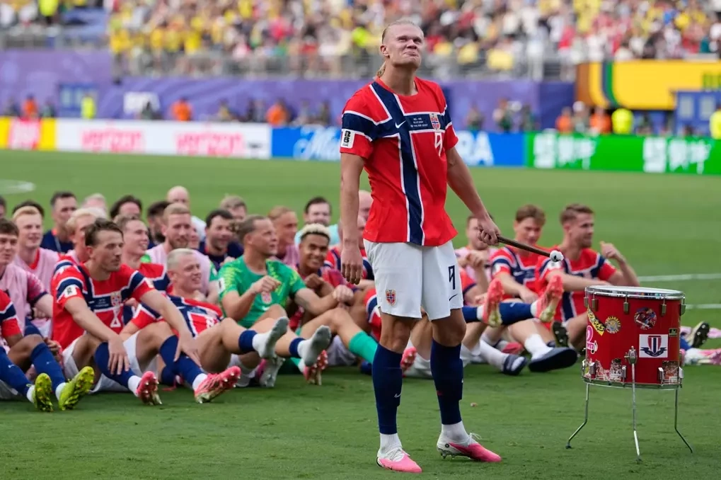 Erling Haaland đánh trống để các cầu thủ Na Uy ăn mừng bằng cách chèo thuyền Viking sau trận thắng Brazil. Ảnh: AP
