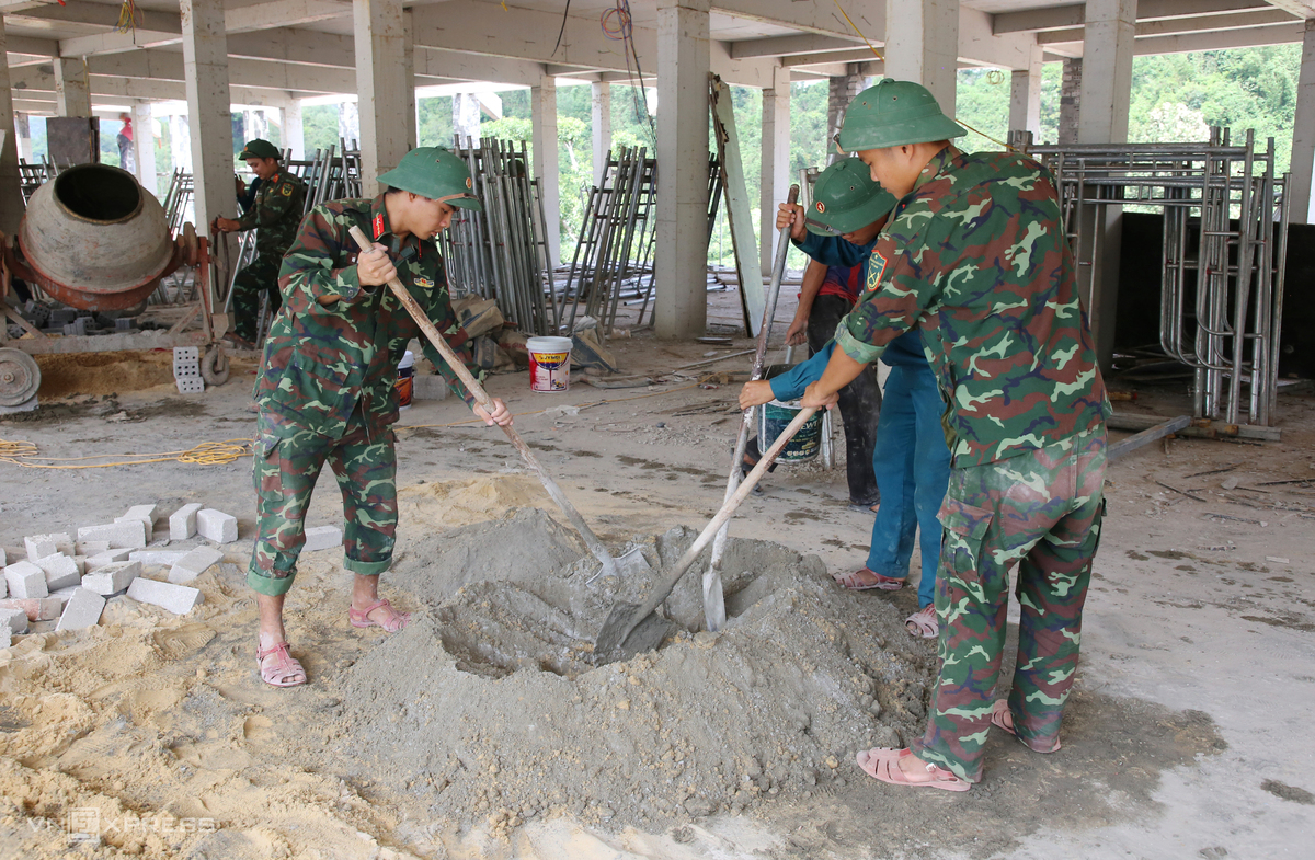 Mỗi sáng, bộ đội hành quân gần 300 m đến công trường trước 6h30. Họ đảm nhận những công việc như vận chuyển vật liệu, buộc thép, trộn vữa, san gạt nền.