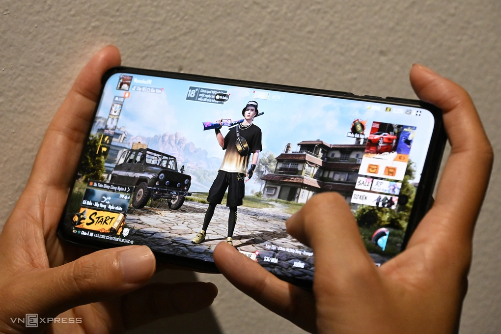 Một người chơi game bắn súng trên điện thoại di động. Giao diện game hiển thị khuyến cáo Chơi quá 180 phút một ngày ảnh hưởng xấu tới sức khỏe. Ảnh: Trọng Đạt