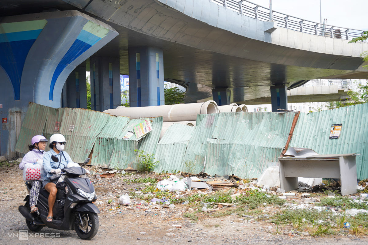 Khu vực nhánh N4 được quây hàng rào tôn, nhiều đoạn đã cong vênh. "Hàng rào tôn sắc nhọn nhô ra, mặt đường nham nhở khiến tôi khá lo lắng mỗi khi đi qua", bà Nguyễn Uyên, trú phường Tây Nha Trang, nói.